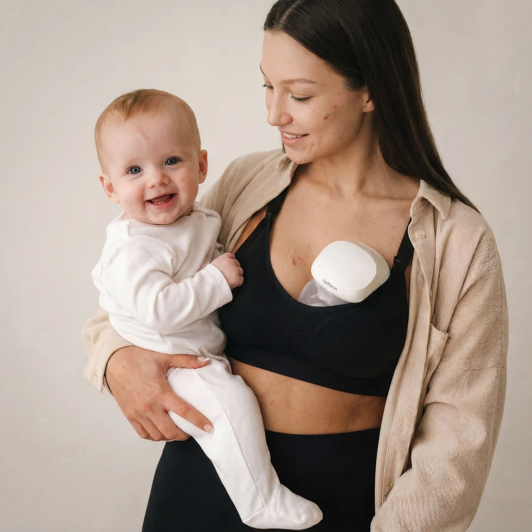 Black active nursing bra pump-compatible smooth cup with drop-clip straps, lifestyle postpartum holding baby shot