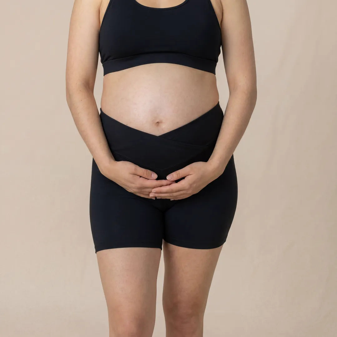 Black maternity bump support short crossover waistband, pregnant model front close view