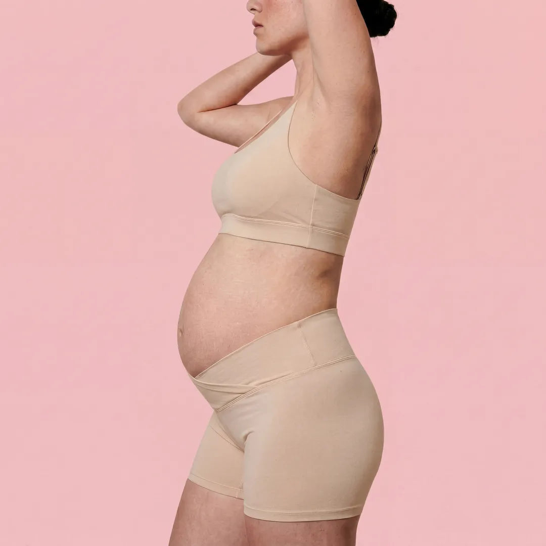 Nude maternity bump support short crossover waistband, pregnant model side view