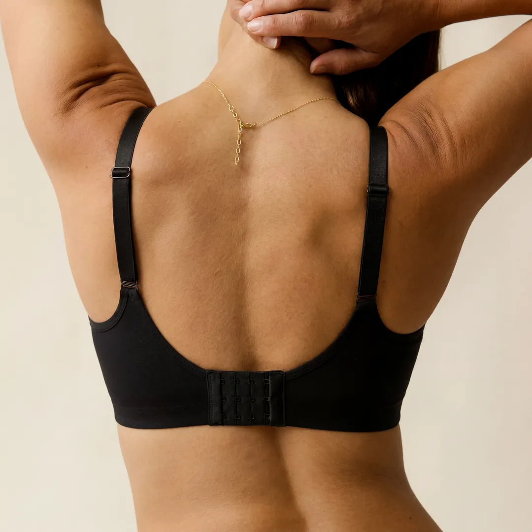 Black classic nursing bra multi-hook back closure adjustable straps, back view arms raised studio shot