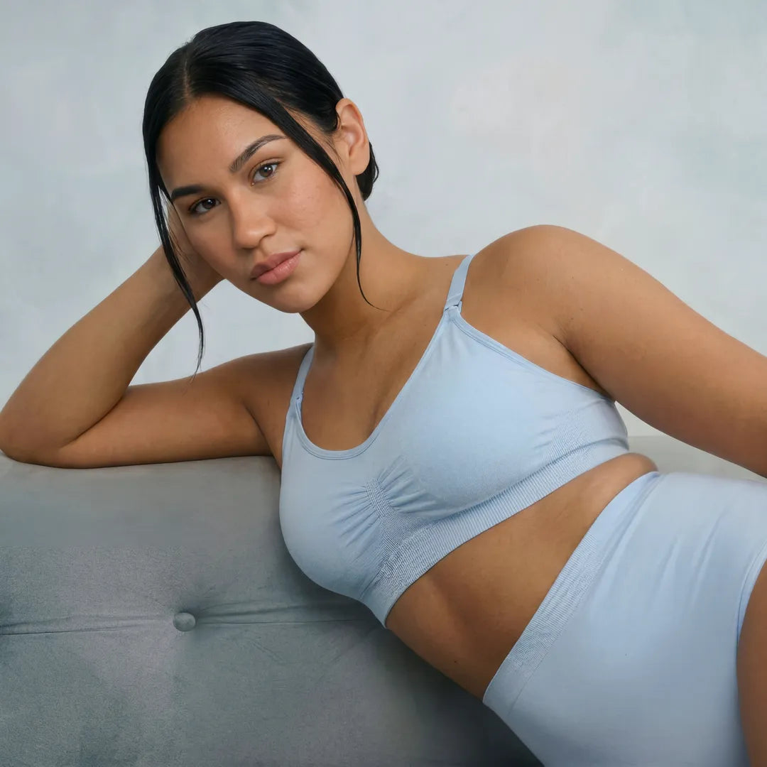 Light blue classic nursing bra smooth gathered cup with adjustable straps, lifestyle reclining shot with matching underwear