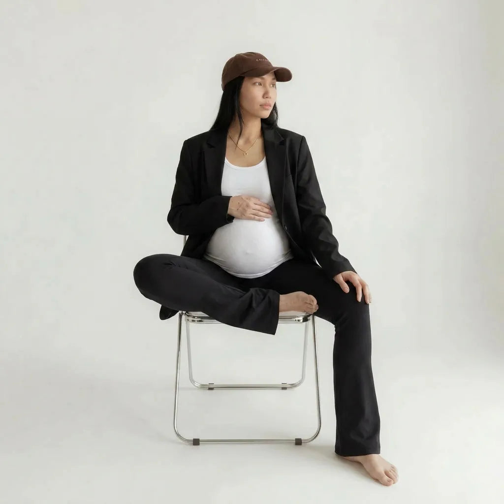 Black maternity flare leggings styled with blazer, seated lifestyle shot