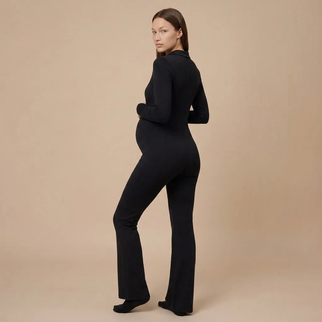 Black maternity flare jumpsuit long sleeve flare leg silhouette, back three-quarter studio view