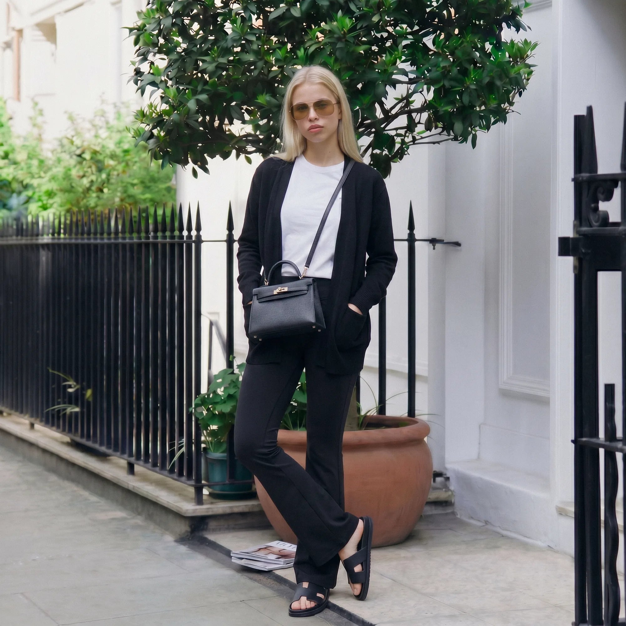 Woman wearing black Florecer high-waisted flare legging styled with a jacket, standing outdoors