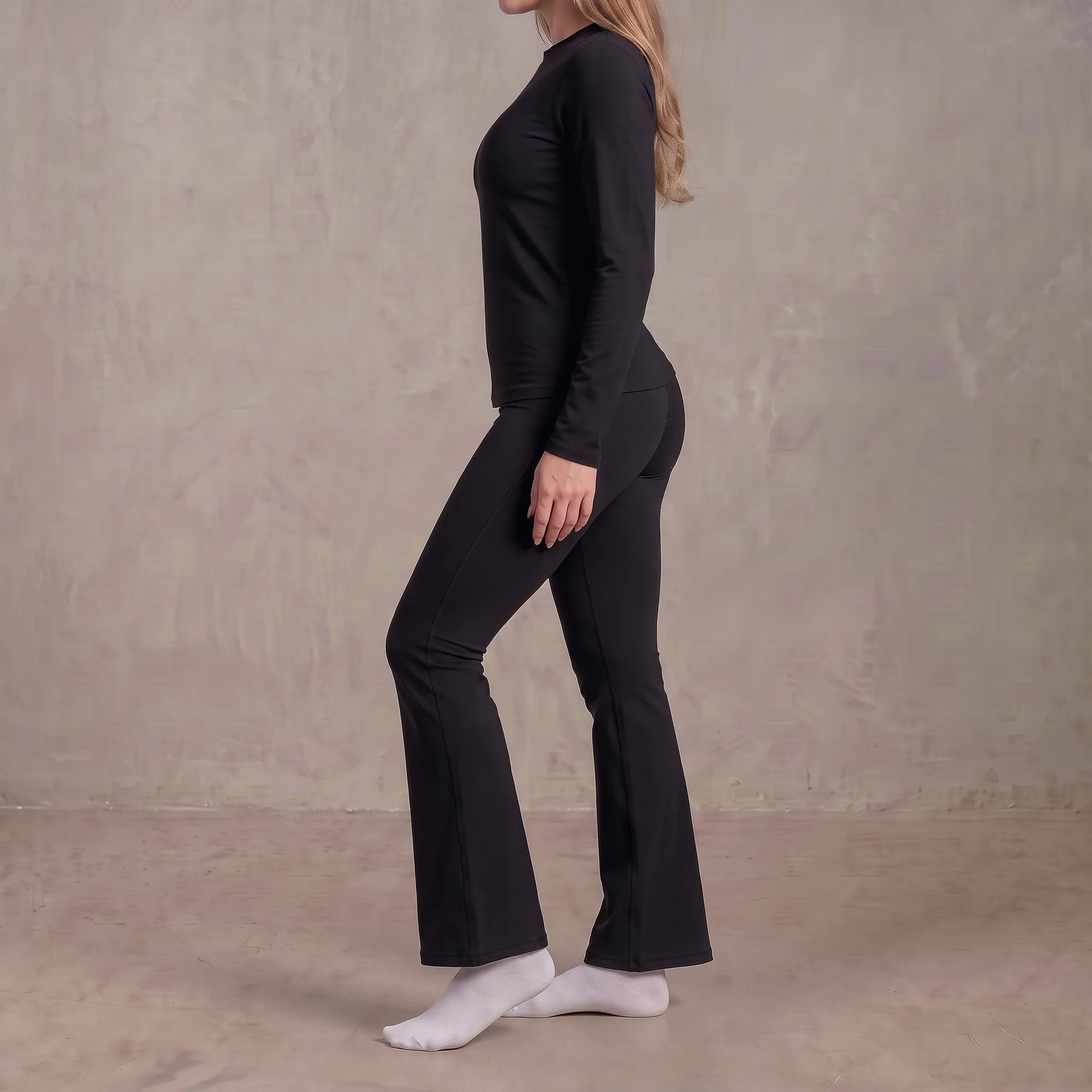 Woman wearing black Florecer high-waisted flare legging, side view