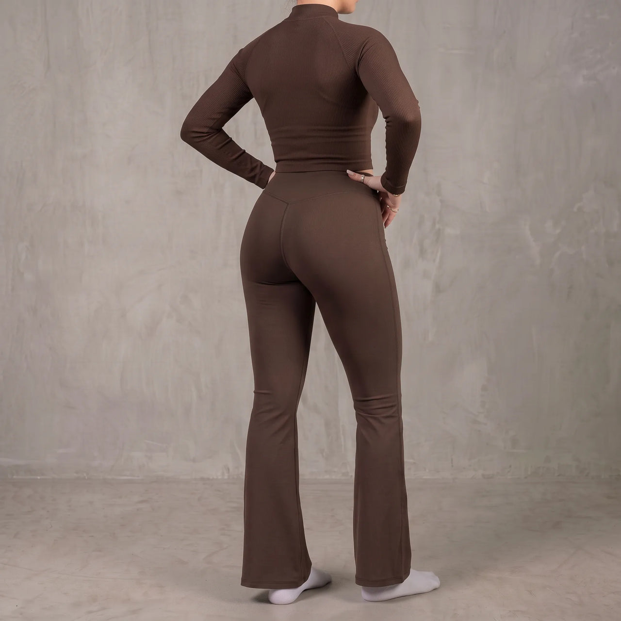 Woman wearing chocolate brown Florecer high-waisted flare legging, back view