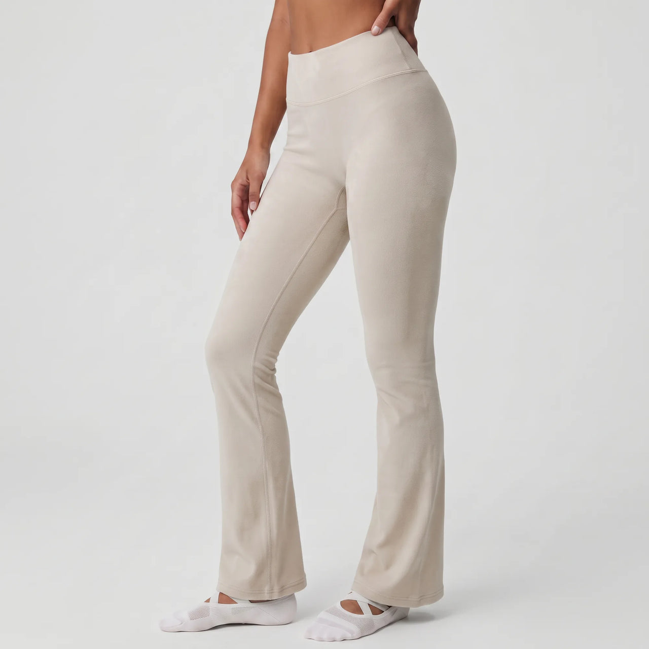 Woman wearing stone Florecer high-waisted flare legging, side view