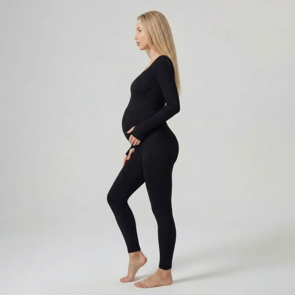 Black maternity jumpsuit long sleeve ribbed bump profile, full length side studio view