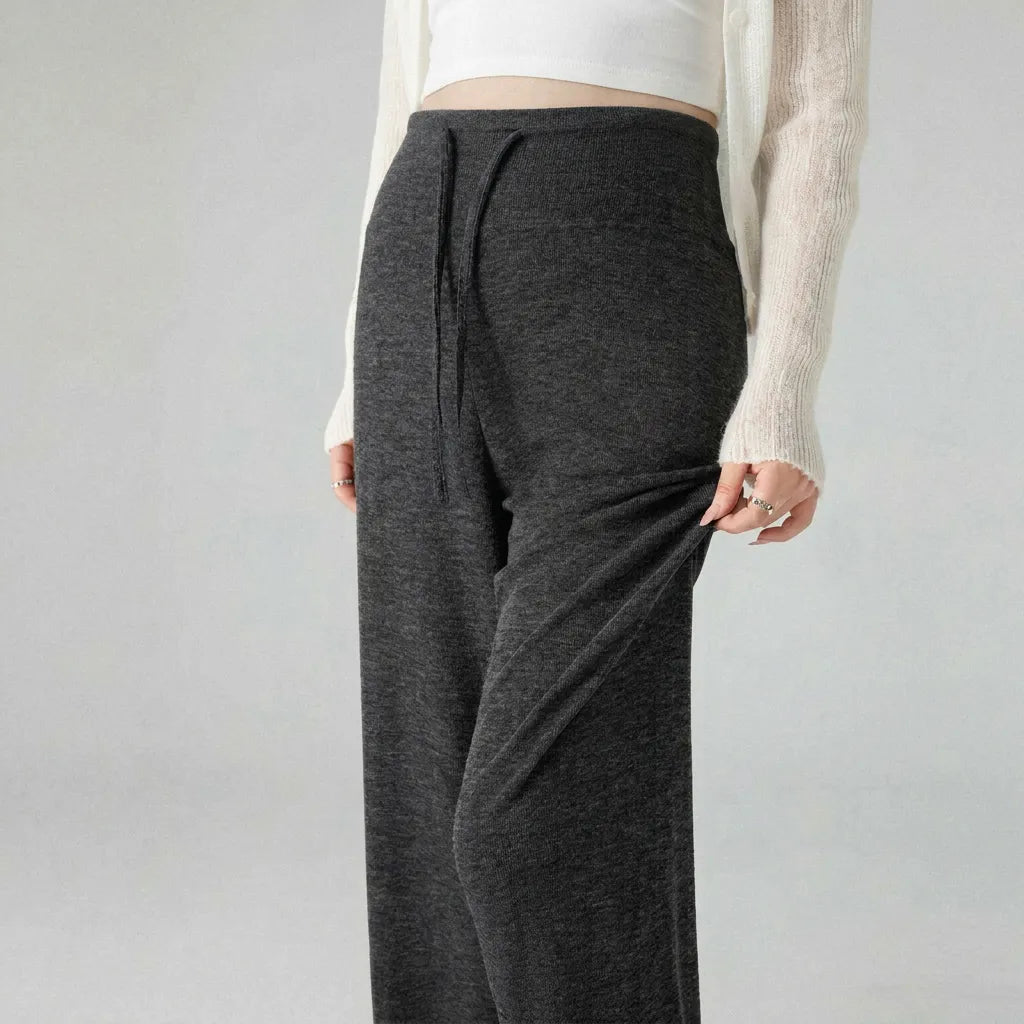 Person wearing dark gray pants on a plain background