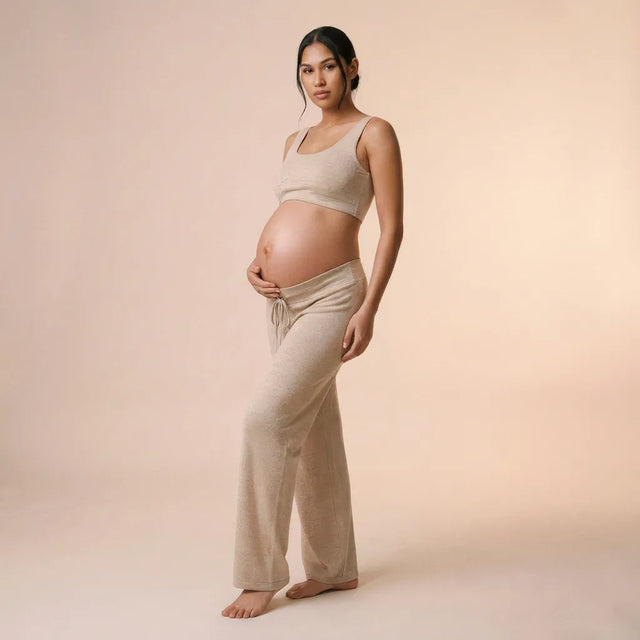 Oat knit maternity trousers with matching bra top, peach background lifestyle
