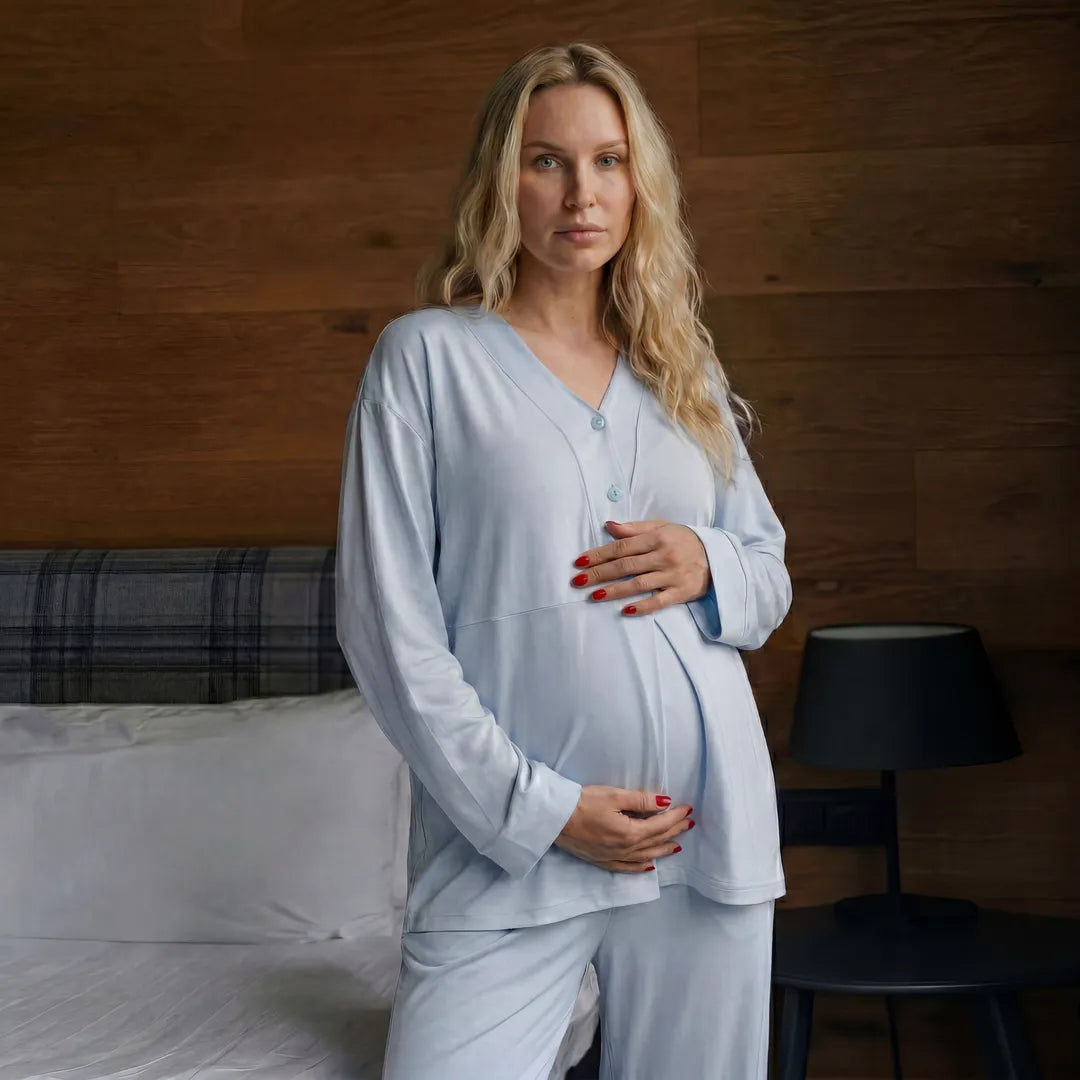 Blue maternity nursing pyjama set V-neck button top detail, bedroom lifestyle close-up crop