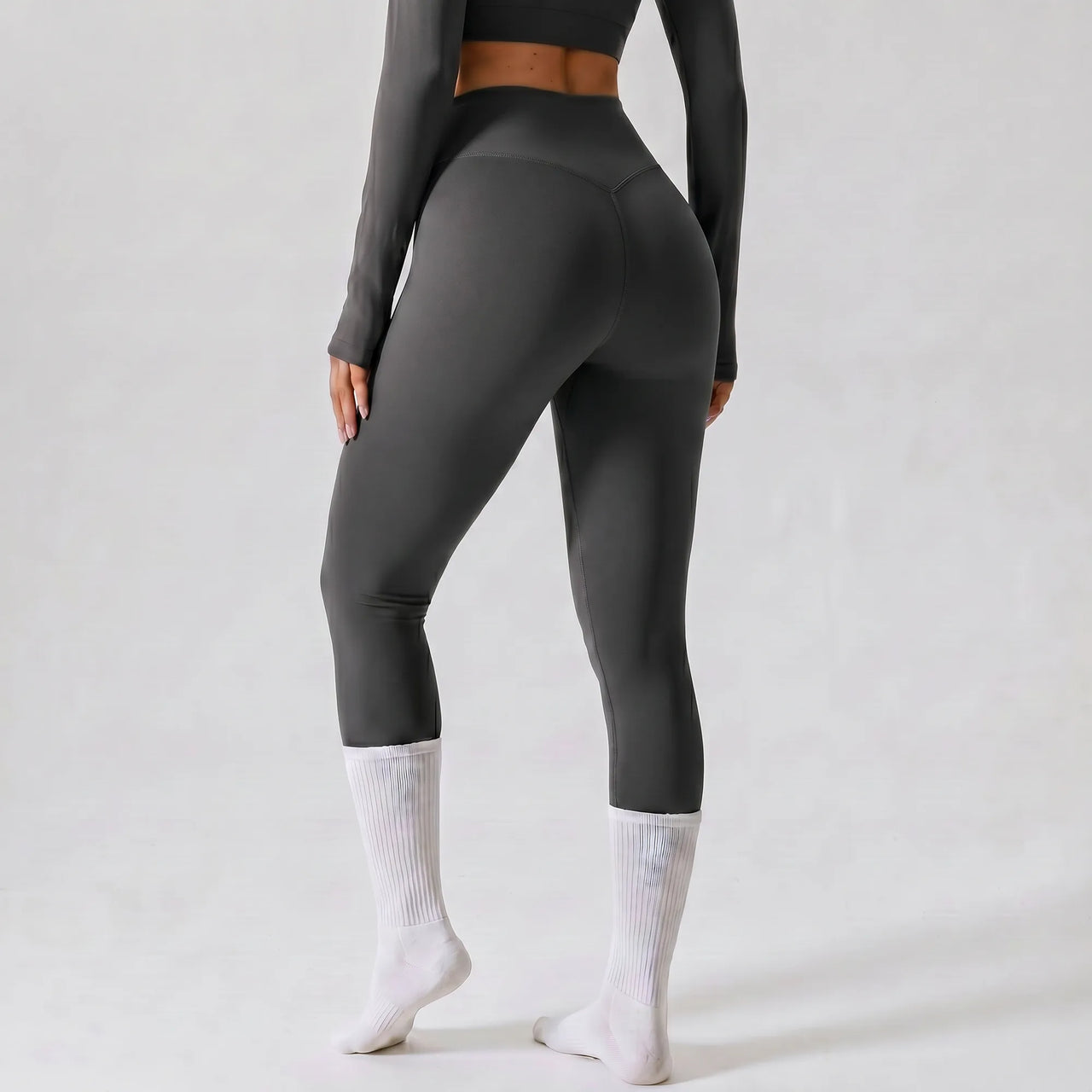 Woman wearing grey Retorno high-waisted postpartum legging, back view