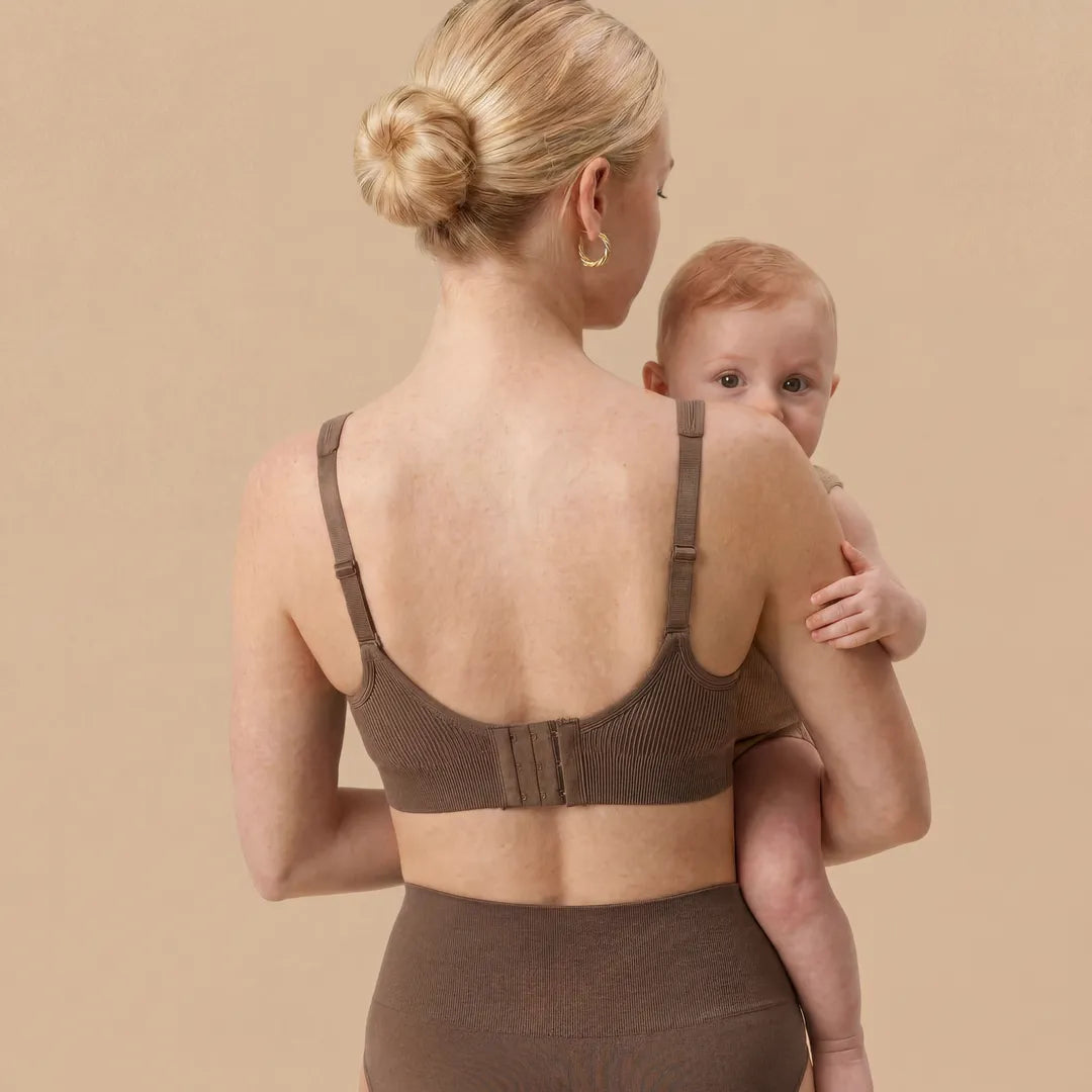 Mocha seamless nursing bra back hook-and-eye closure with adjustable straps, back view lifestyle holding newborn shot