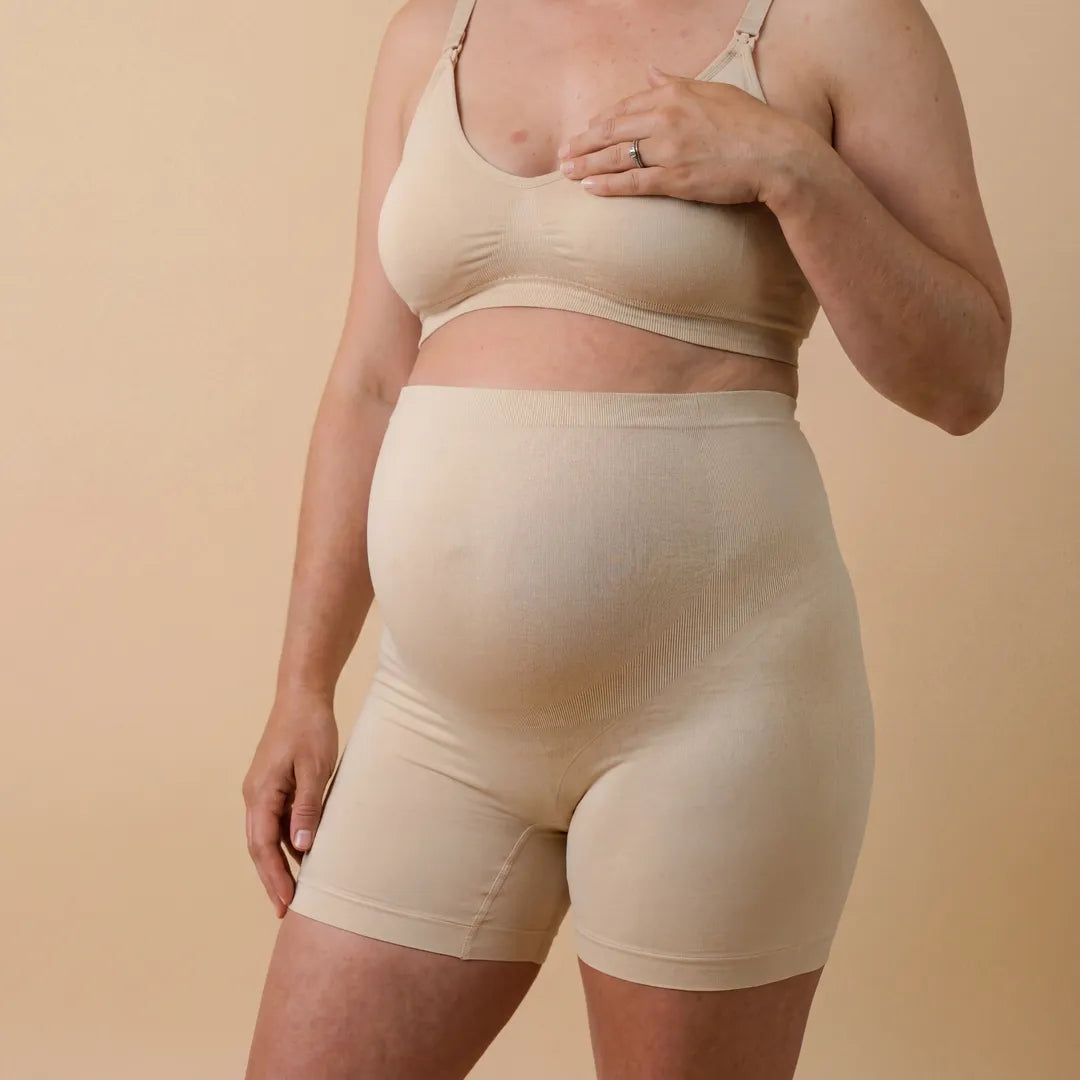 Person wearing a beige bra and shorts set against a beige background