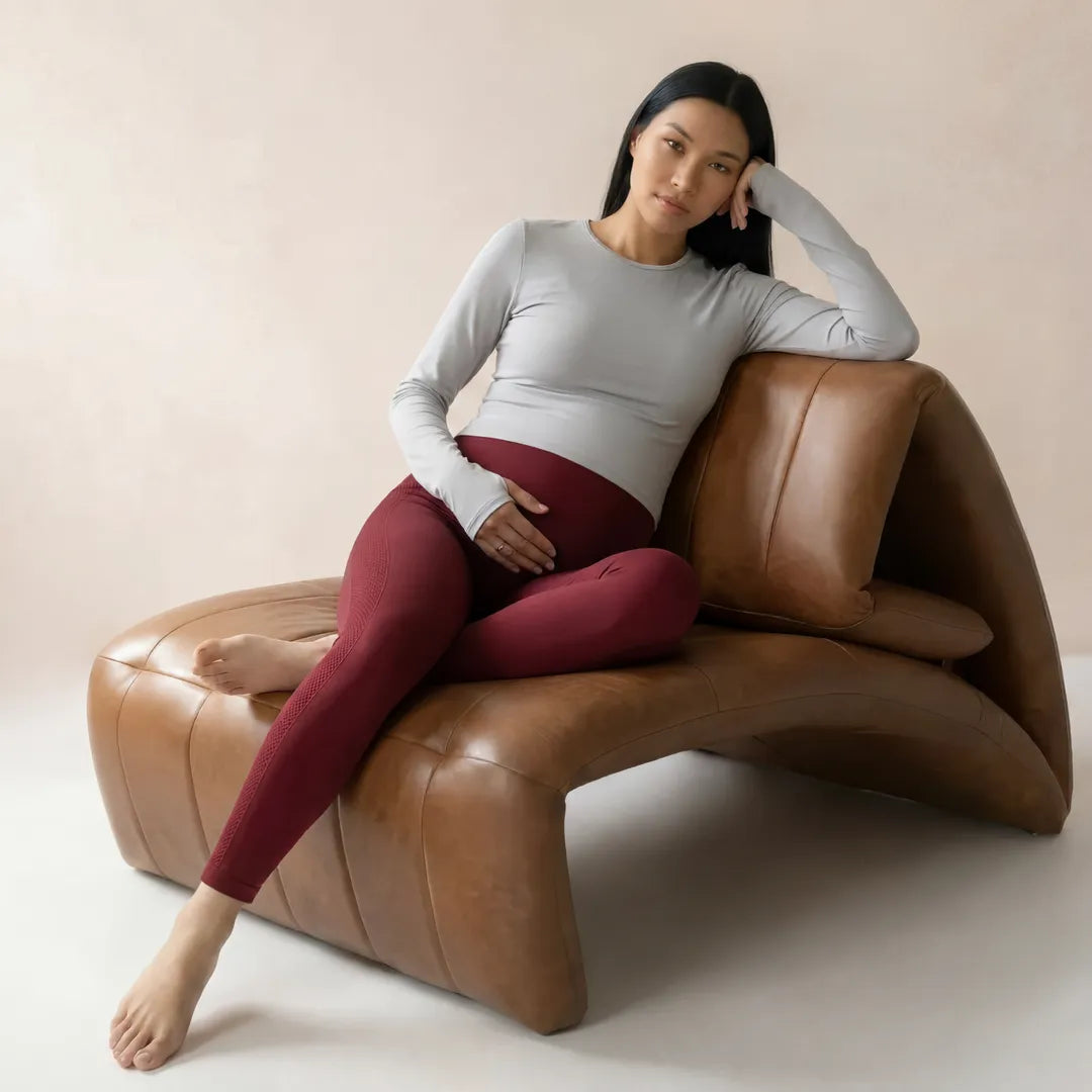 Burgundy maternity seamless leggings over-belly support, seated lifestyle shot