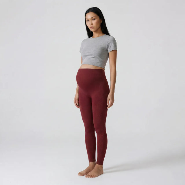 Burgundy maternity seamless leggings high rise over-belly panel, three-quarter full length view