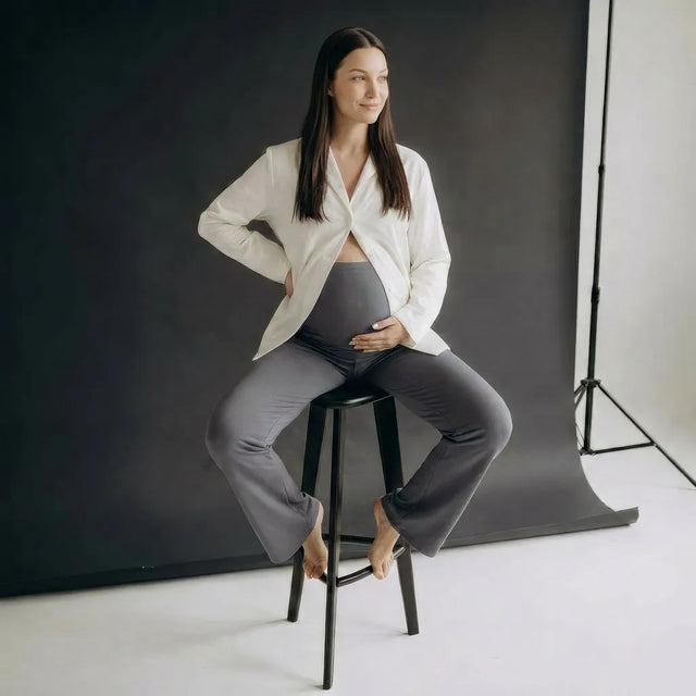 Charcoal seamless yoga trousers styled with white jacket, seated lifestyle